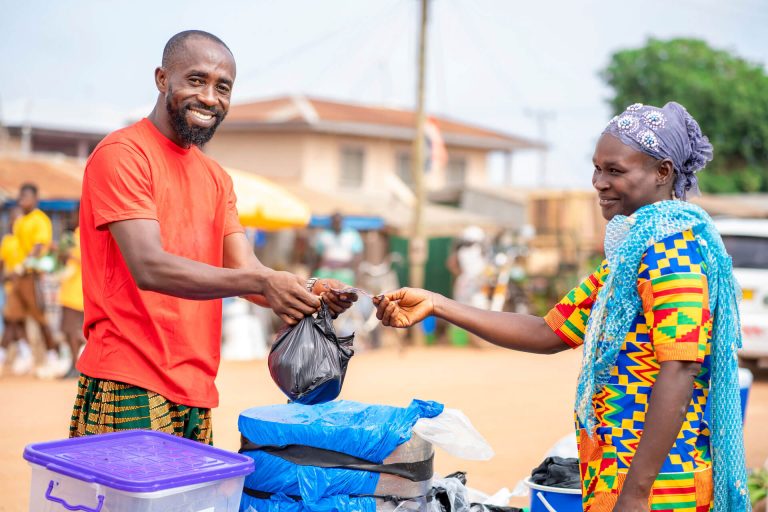 A seller in Africa selling a woman an item and she is paying him