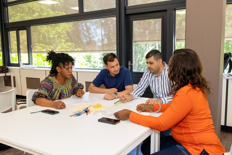 Group of four people at a table working as a team