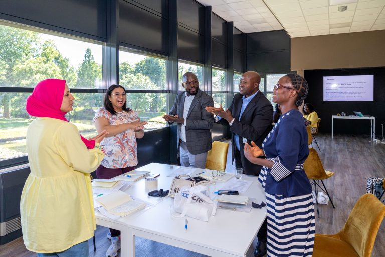 Teachers standing around a table smiling and talking