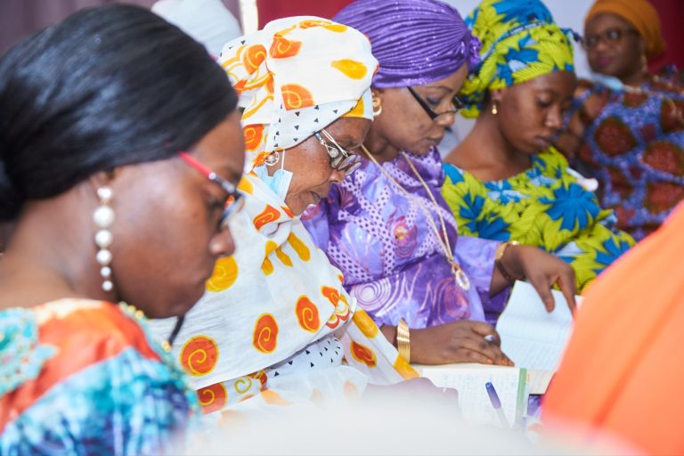 Malian women writing in their notebook during a training session